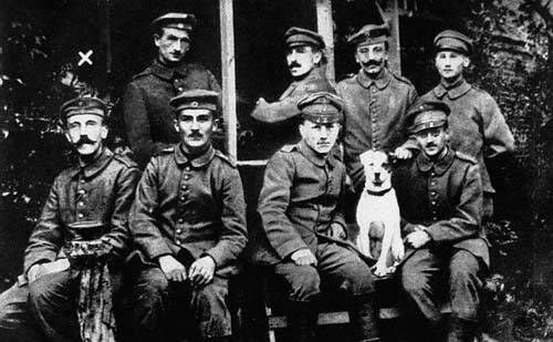 That is a young Hitler on the left, below the 'x', with the unfortunate moustache. His dog Fuchs, also pictured, remained by Hitler through the war until stolen by a railway worker.