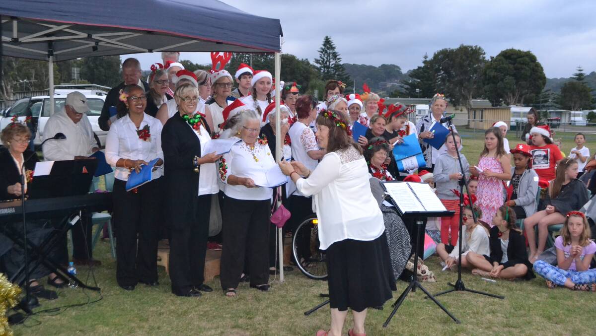 The Narooma Community Choir at last year's Narooma Carols by Candlelight at NATA Oval where a large crowd gathered despite overcast skies.  