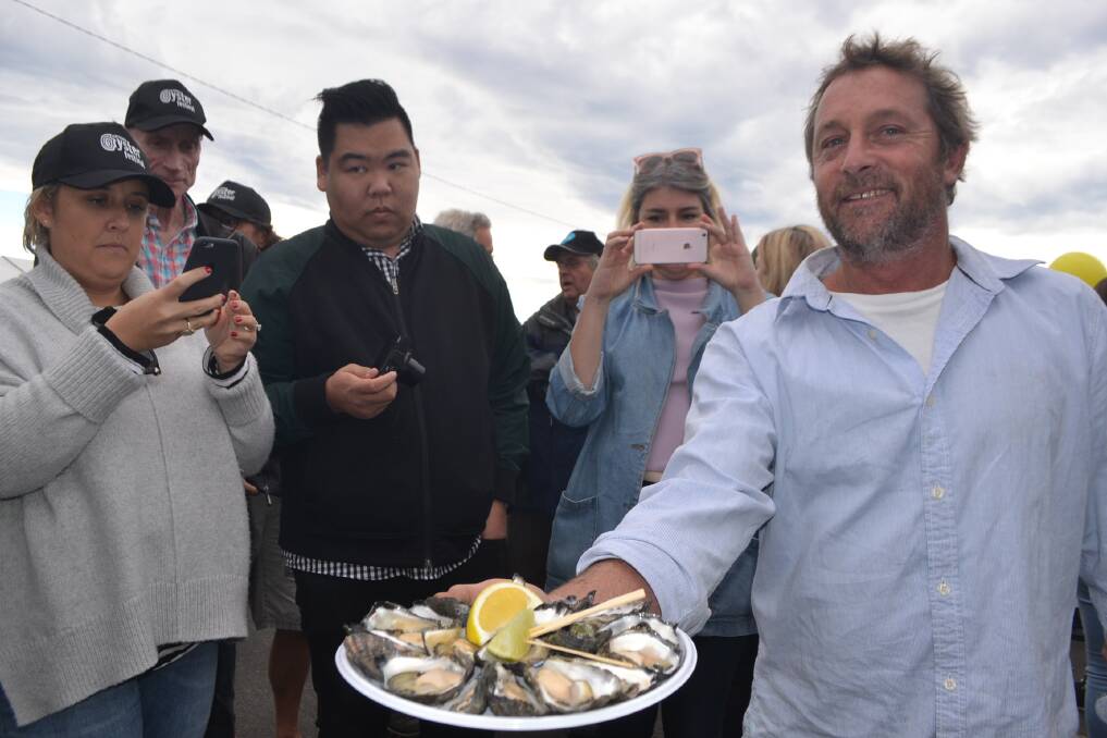 Award-winning Clyde River oyster grower Jim Doyle of Doyle's Oysters brings out a plate of his finest oysters for visiting food writers at the Narooma Oyster Festival. 