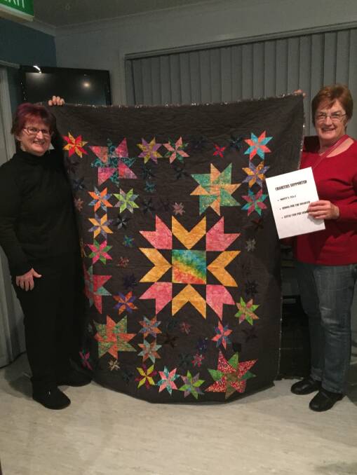 Sandra Doyle, Secretary and Narelle Davis, committee member hold up the Raffle Quilt for 2017 Dalmeny Quilters’ Exhibition.
