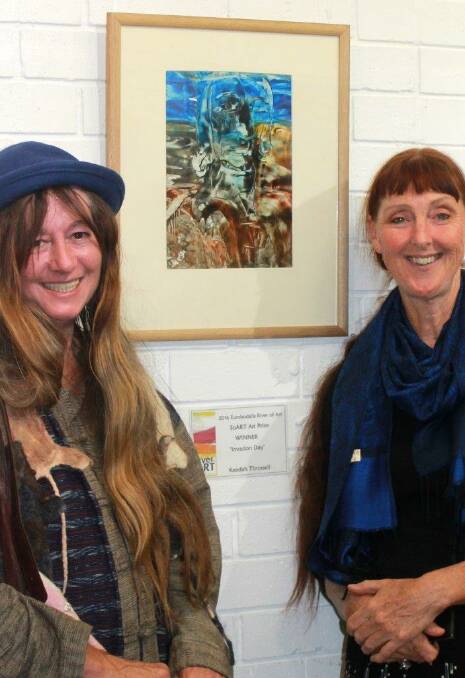 Artists Keedah Throssell, left, and Lesley Whale stand beside Keedah’s entry entitled “Invasion Day”, which won the Eurobodalla River of Art 2016 Art Prize.
