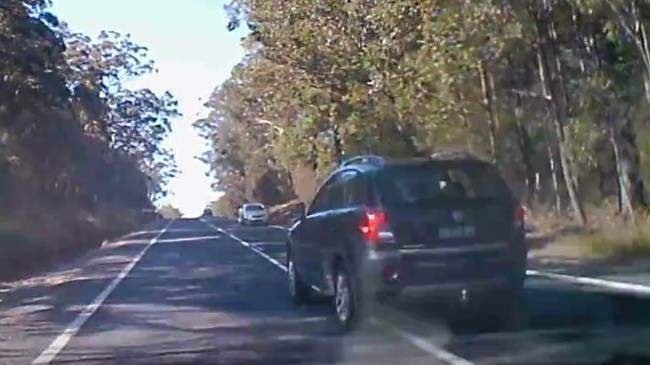 The dash cam footage shows the dark SUV just missing the lighter-coloured vehicle ahead after overtaking. 