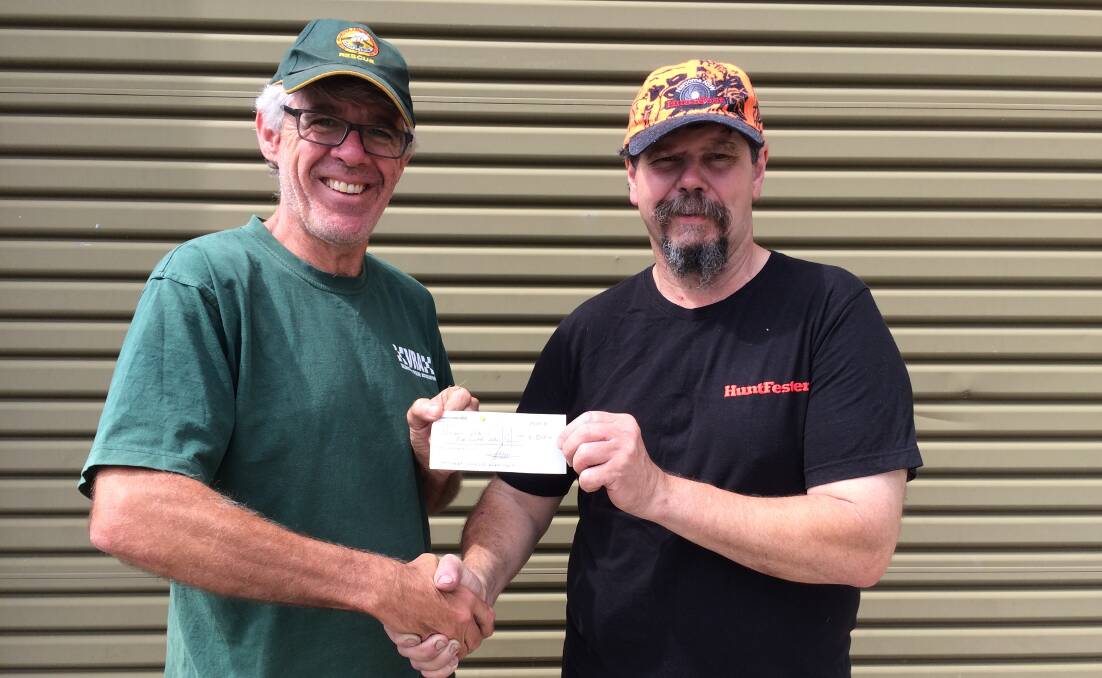 Grant Harrison of the Narooma VRA rescue squad receives a donation from Jeff Garrad representing the South Coast Hunters Club.  
