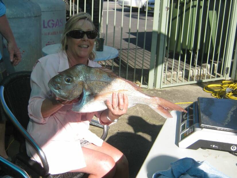 PRIZE WINNER: Annette Turner holds a snapper at the weigh in scales. She won the women's senior individual catch award topping more than 15kg. 
