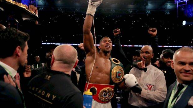 Wrapping up: Heavyweight champion Anthony Joshua pictured wearing two of the three belts earned after an 11th round knockout of Wladimir Klitschko. Photo: NICK POTTS
