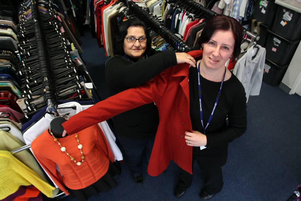 Anglicare staff Georgina Samios, left, and Zaklina Bajmakoski try on some of the second-hand clothing for sale in the op shop as they look forward to National Op Shop Week. Picture: GREG TOTMAN