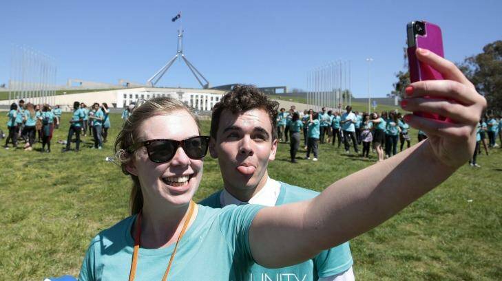 Liz Rhodes takes a selfie of her and Darcy Lower as 350 young people get into formation to spell out their anti-poverty message. Photo: Jeffrey Chan