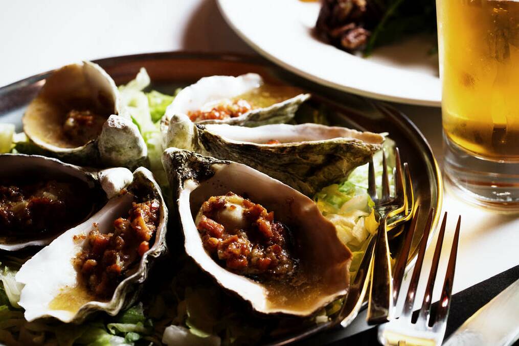 Locally sourced oysters come chargrilled, topped with bacon and a creole mustard cream. Photo: Kristoffer Paulsen