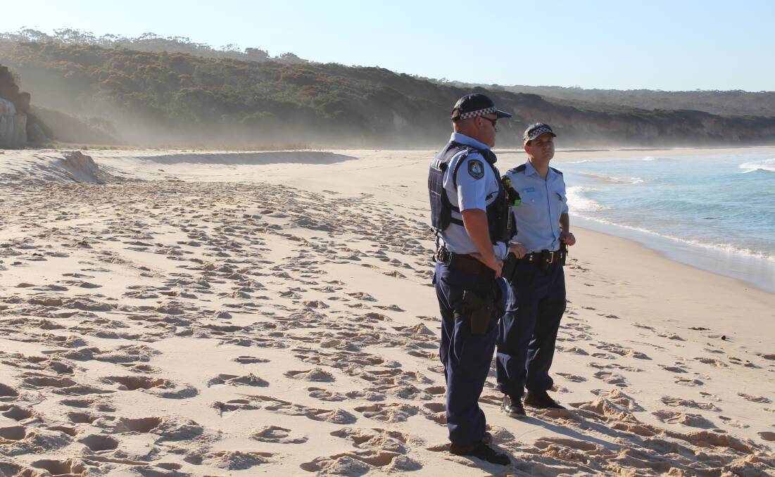 Terrace Beach, in the Ben Boyd National Park, near Eden, where a ten-year-old child died after a sand dune collapsed on Monday. Police officers are standing to the right of where the collapse occurred.