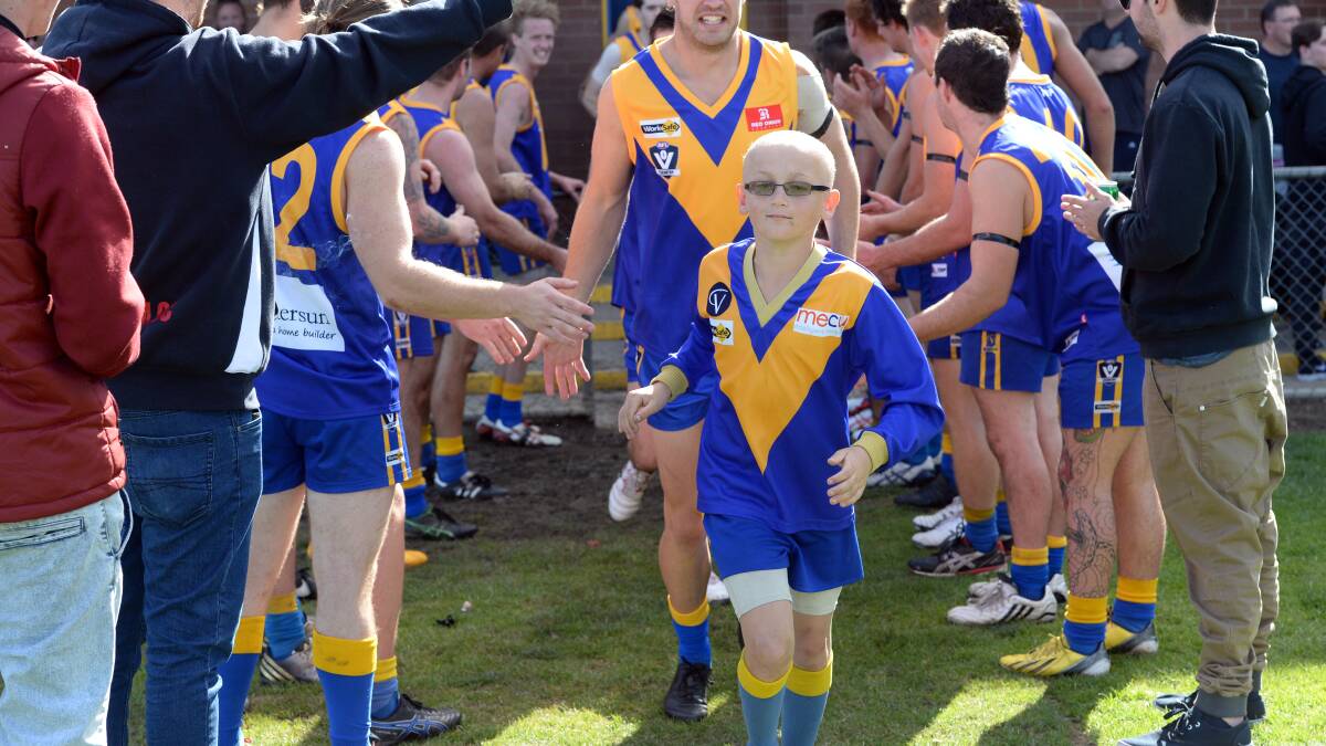 Hodgkin's Lymphoma patient, and under 10 player, Toby Cahill leads the Sebastopol football team onto the ground for their first Ballarat Football Club game of the 2015 season. Picture: KATE HEALY