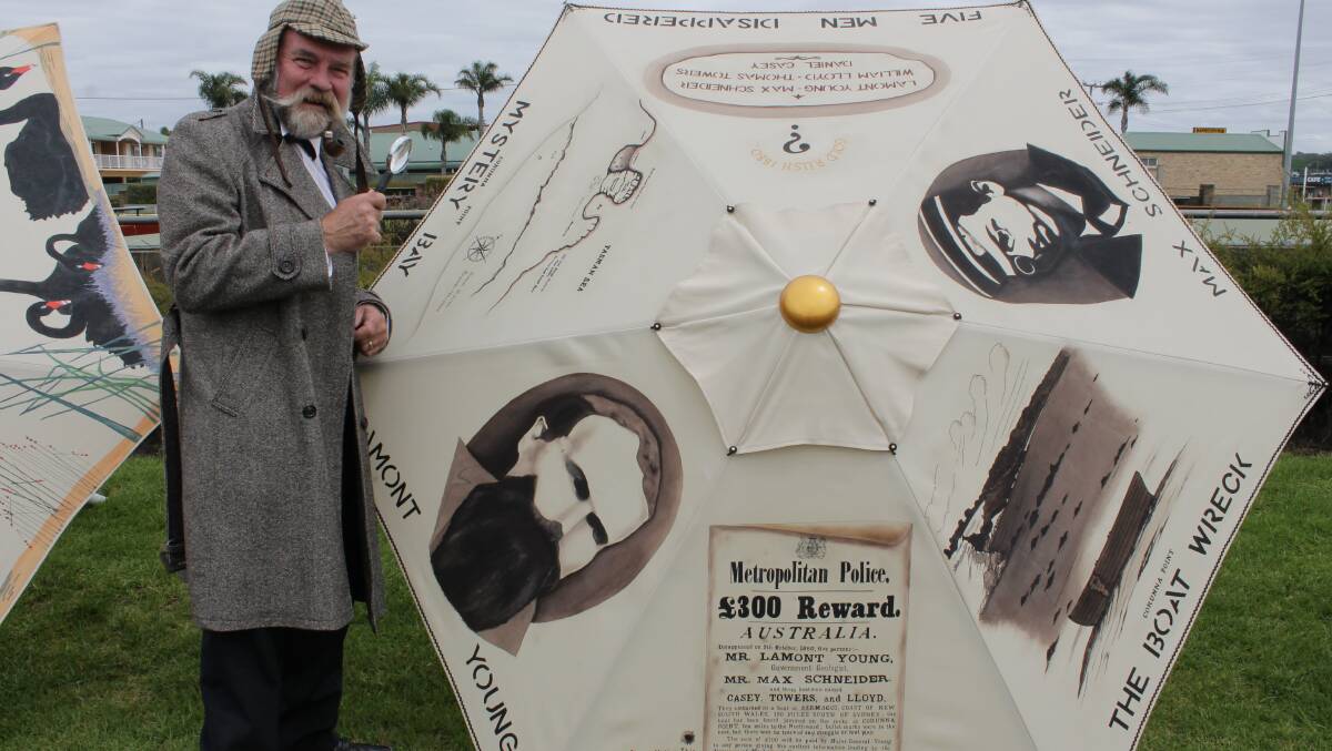 Artist Paul Fletcher, dressed in a Sherlock Holmes–themed outfit, examines his umbrella titled “Lament for Lamont”.