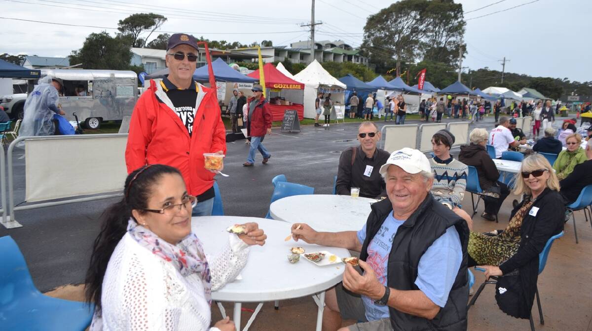 LOCAL DINERS: Orit Karny Winters and Mike Young from the Narooma chamber enjoying oysters with George Delic at the Narooma Oyster Festival. Photo Stan Gorton