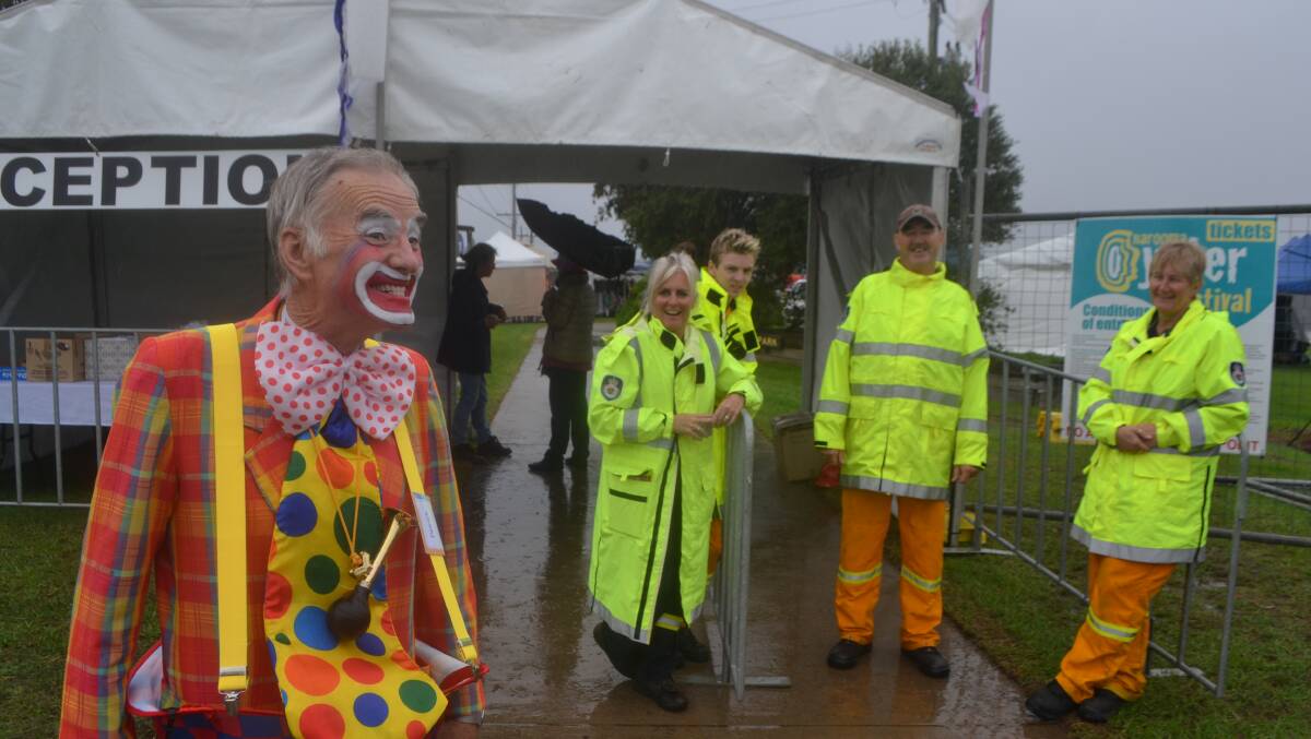 COLOURFUL CLOWN: Patrick the clown greets the very first visitors to the Narooma Oyster Festival with RFS volunteers Sean Cavanagh, Mick Marchini, Jane Taylor and Gilly Kearney in the background. Photo Stan Gorton 