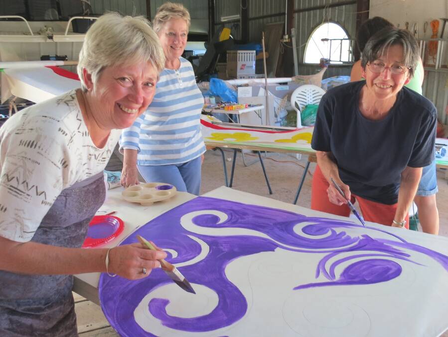 Painting one of the many kites for Narooma Oyster Festival are Ros Barr and Vivienne Bowe-Wood, watched by kite organiser Judy Glover.  