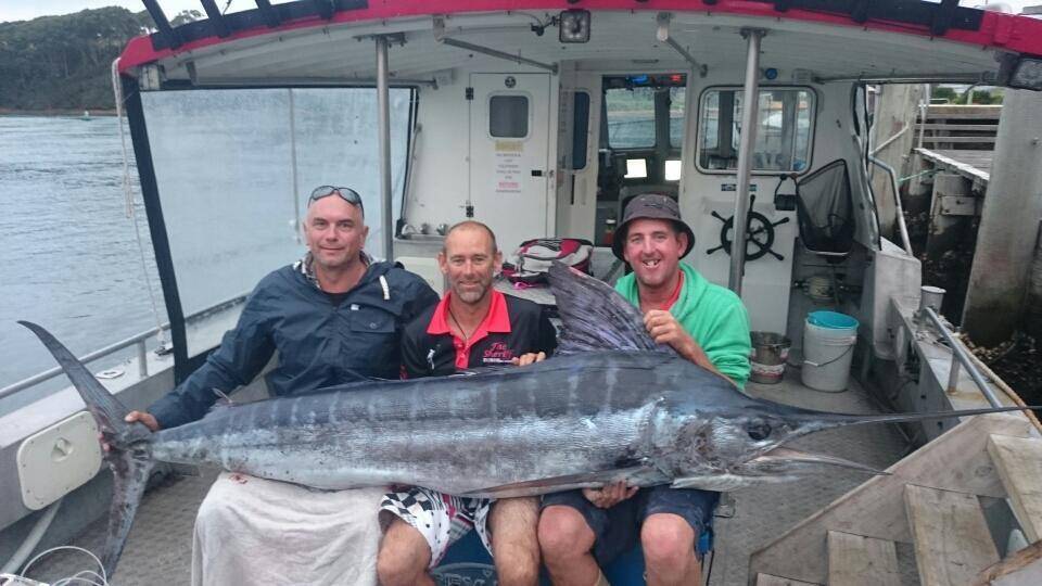 CATCH OF THE DAY: The Sheriff crew with a striped marlin caught Tuesday off Tathra. The three fishermen are customer Jason from Bredbo with skipper Jason Bunney and deckhand Matt Betts.