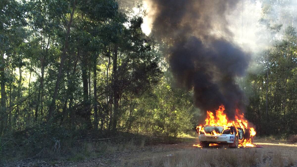 BURNING: Cooma based Andrew Penny had a fiery exit from the rally as his Subaru WRX erupted in flames on the opening stage of the day and burning to nothing more than a shell. 