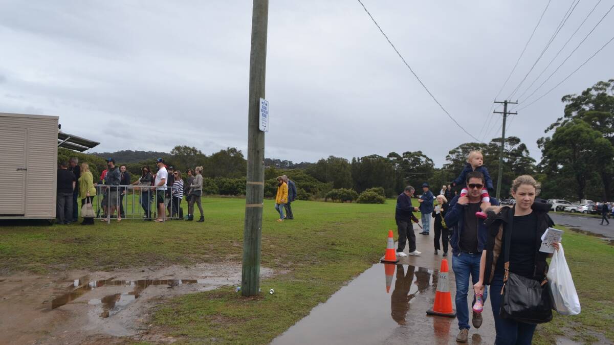 ENTRY TIME: The crowds arrive at the Narooma Oyster Festival in the rain. Photo Stan Gorton