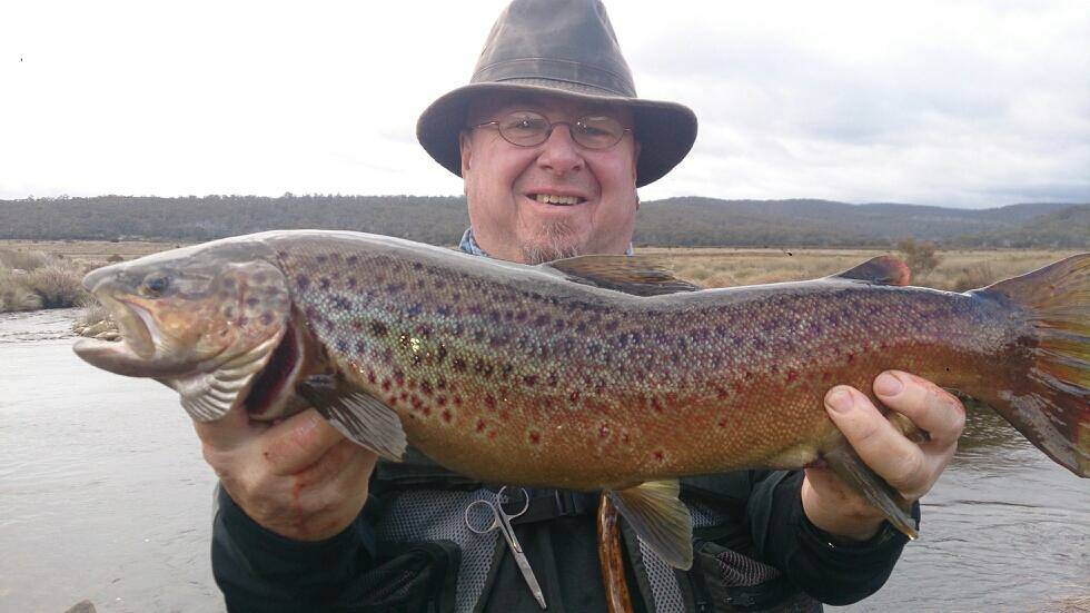 TROUT TIME: Ian "Big E" Phillips who is a regular at Narooma Sport and Game Fishing Club with a typical pre-spawn brown caught on the Eucumbene River in pleasant mild conditions. 