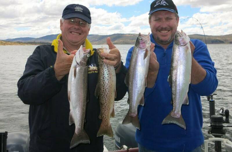 FISH MYTHBUSTERS: Nick Elliott and David Hogan with a fine brace of rainbow and brown trout caught with Snowy Mountains fishing guide Steve Williamson recently. 