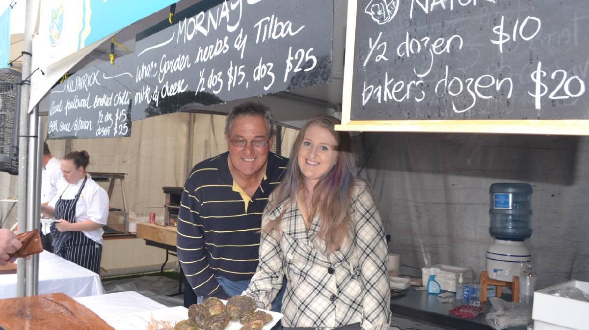 LOCAL OYSTERS: Narooma oyster farmer David Maidment and Beth Connor from The Whale at one of the local oyster stalls at the Narooma Oyster Festival. Photo Stan Gorton