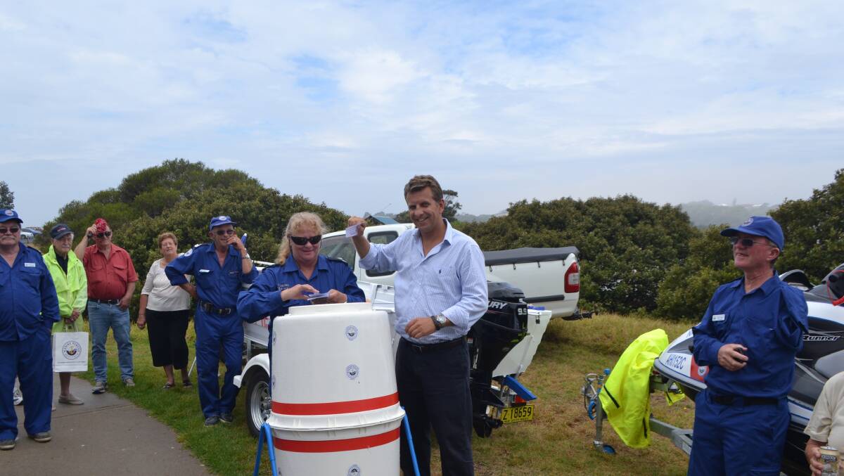 WINNING TICKET: Member for Bega Andrew Constance draws out the winning ticket in the Marine Rescue raffle of a Quintrex tinny on Saturday. 