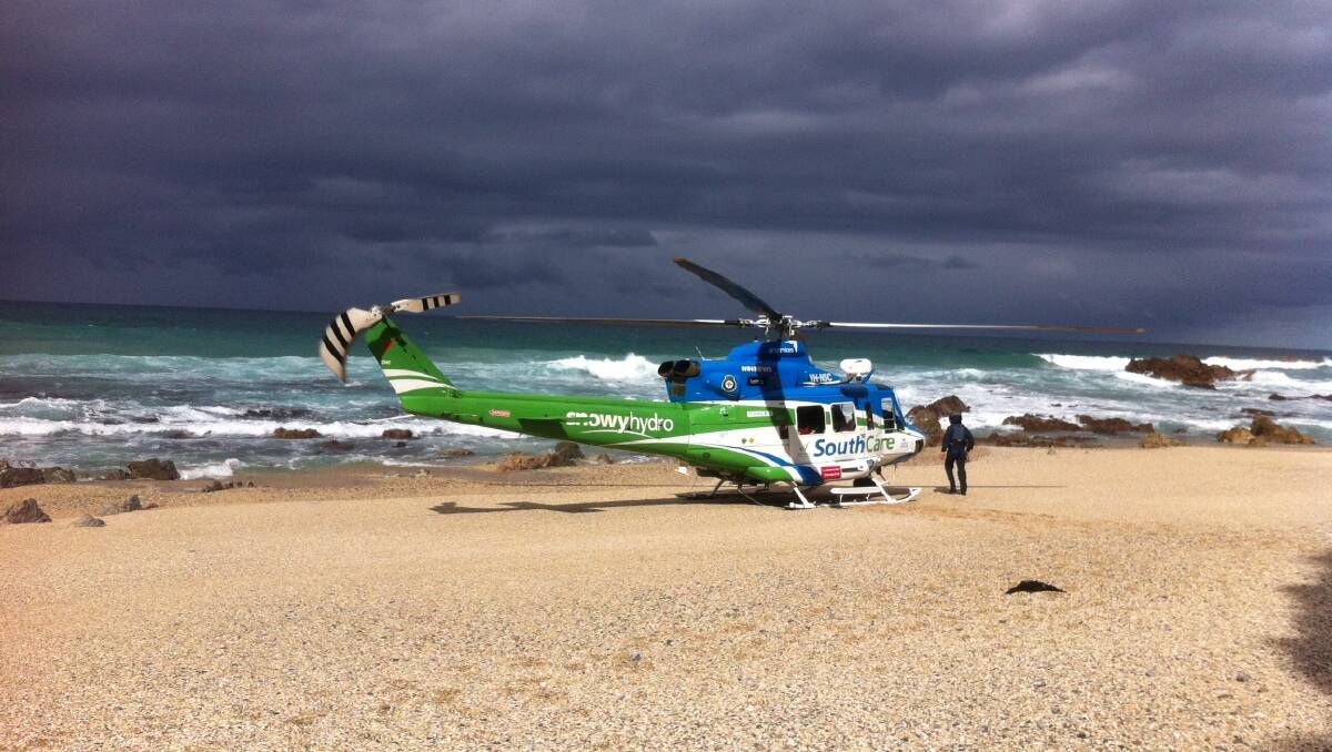 CHOPPER RESCUE: The Snowy Hydro SouthCare chopper pilot performed a daring manoeuvre landing gently on the narrow beach at Camel Rock near Bermagui, staying at the controls as the quick transfer of the patient by the Ambulance paramedics took place.