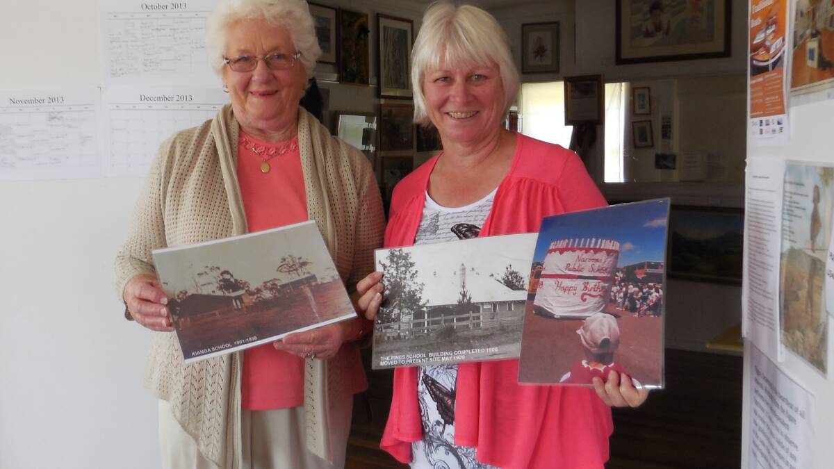 HISTORICAL MEETING: Elaine Noble and Sylvia Gauslaa show some of the historic photos of Narooma Public School to the recent Narooma Historical Society Meeting. 