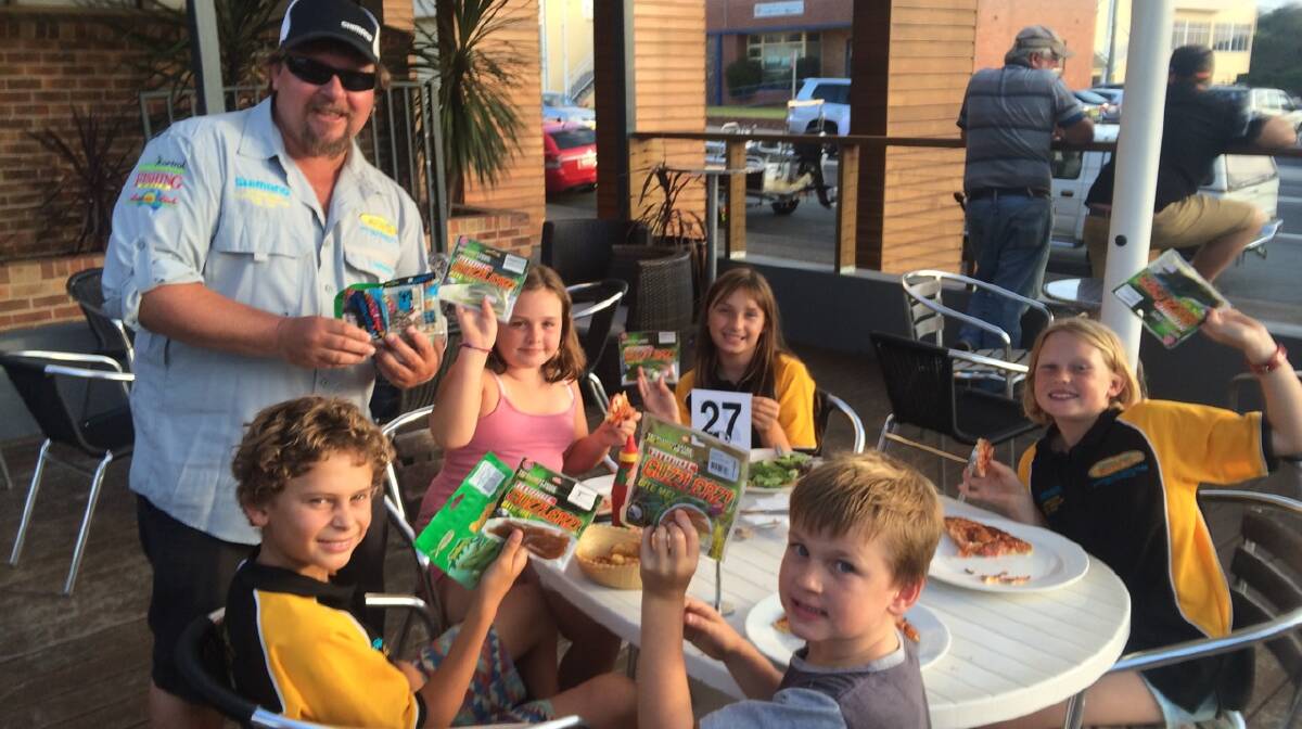FUTURE ANGLERS: Narooma Flathead Classic official Stuart Hindson hands out some soft plastics to local kids at O’Briens Hotel including Digger Cowie who competed with his dad Hoots.