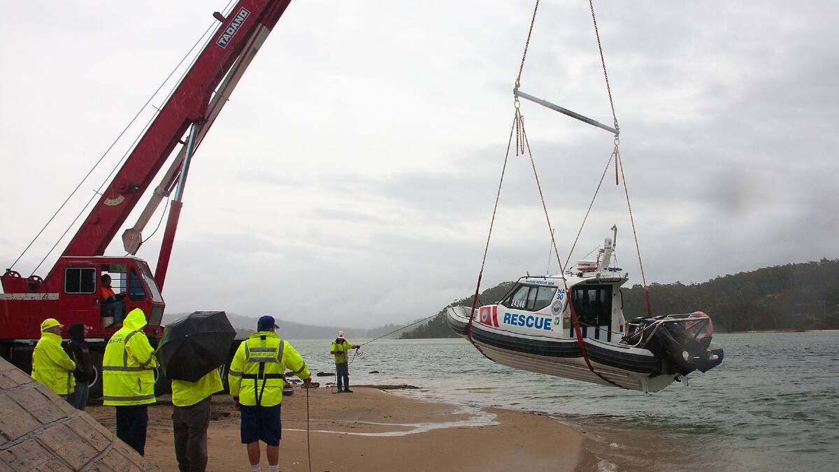 VESSEL FAREWELL: The old Gemini 8.5 rescue vessel is lifted out by Marine Rescue Narooma at the Narooma Bridge on Thursday in the rain. Photo by Brian Gunter  