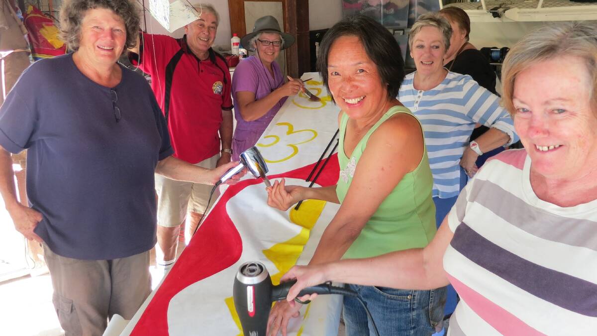 KITE PAINTING: Painting the giant serpent kite for the Narooma Oyster Festival are Dorothy Noble, Tony Pye, Chris Perrott, Oung Niennattrakul, Judy Glover, June Welsh and Christal Bray. 