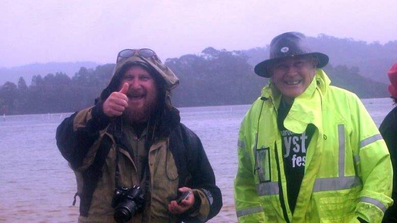 SMILES Smiles despite the rain were a big part of the successful festival – Narooma News editor Stan Gorton and Tony Pye braving the rain to view the kite project on Wagonga Inlet.  Photo by Rosy Williams 