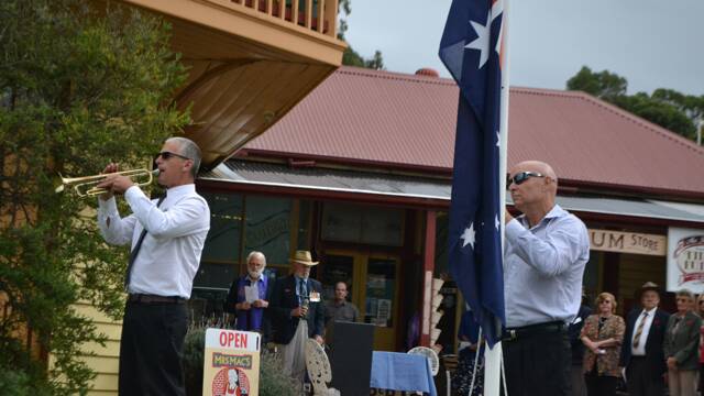 FLAG LOWERING: Keith Morgan plays the bugle while the flag is lowered at the Tilba War Memorial on ANZAC Day.
