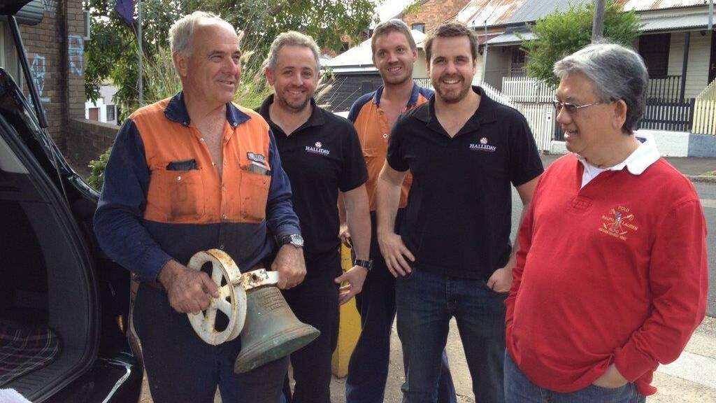 BELL DELIVERED: Henry Hendra of Narooma (right) back in early 2013 delivers the old Narooma Public School bell to engineers Robert Halliday, Trent Churchland, Chris Bradley, who went to school at Narooma, and Luke Halliday in Sydney. 