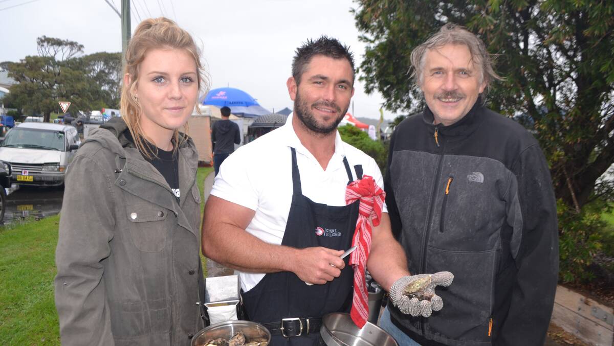 FREE OYSTERS: Narooma Oyster Festival organisers Tamara Zielinski and Tim Burke with fifth generation Batemans Bay oyster farmer John Ralston from Oysters Unplugged who was offering free oysters to those arriving. Photo Stan Gorton. 