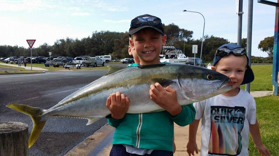 KID KING: 7 year old Oscar Stepanek very happy with his 9kg kingie caught on Monday - dad was more than happy to help him get it in the boat. 