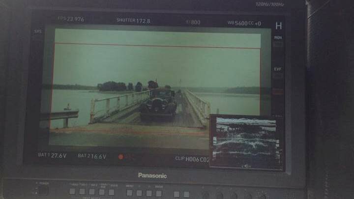 AND ACTION: The director was able to keep track of the car crossing Wallaga Lake bridge through his technical equipment. Photo by Josh Mccue 