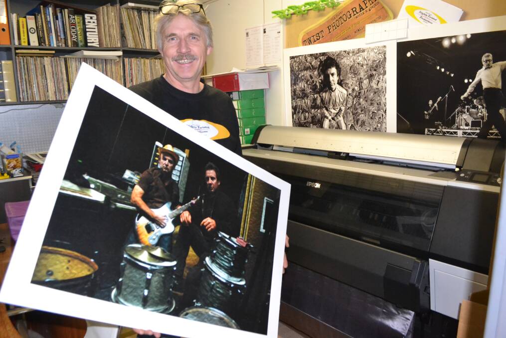BLUES PRINTS: Photographer and graphic artist Tim Burke in his Narooma studio with a print of his work that is the latest album cover for The Backsliders who will be appearing at the Narooma Blues Festival again this year. 