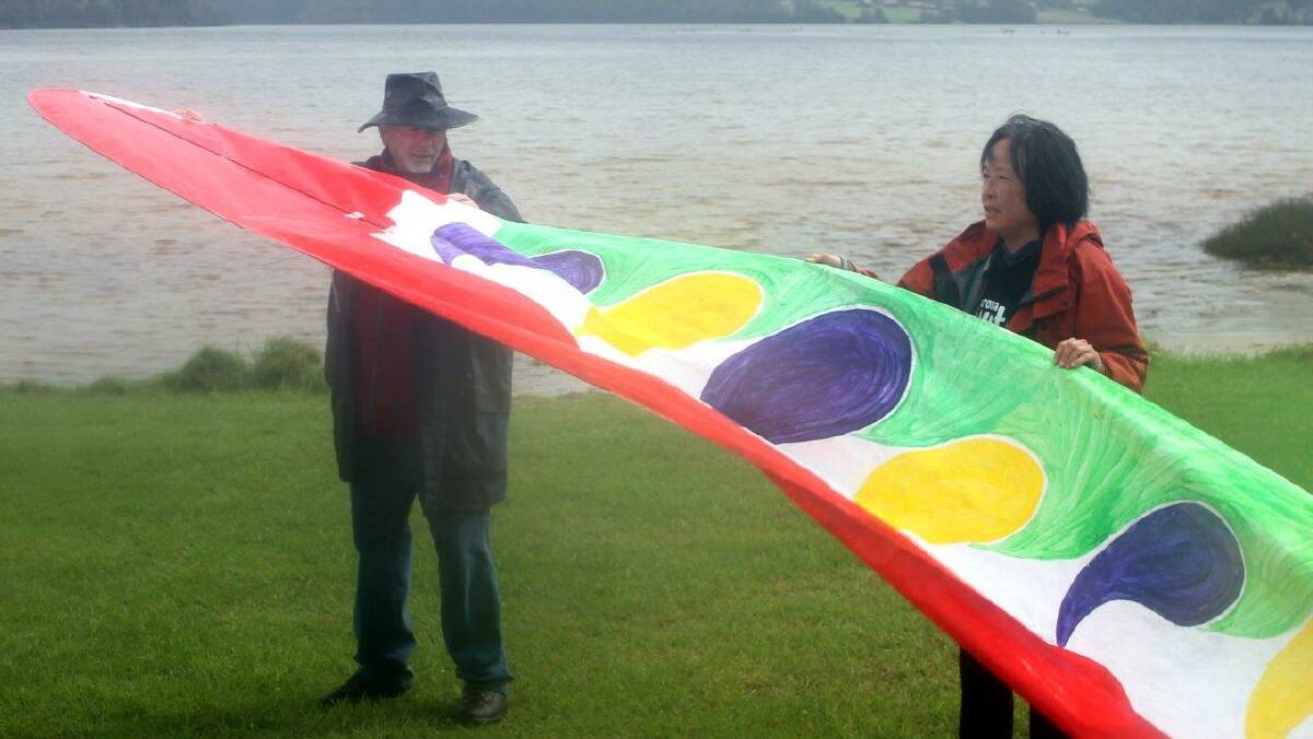 SERPENT KITES: One of two serpent shaped kites made by local volunteers is readied for flight by Richard Nipperess and Oung Niennattrakul. Seven local community clubs also made kites to fly. Photo by Rosy Williams
 