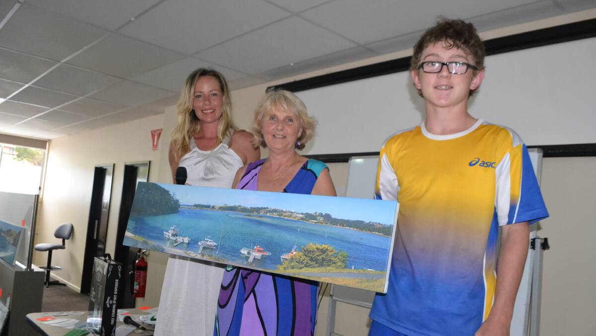 PAINTING WINNER: Pauline Wilcock wins one of the beautiful paintings at the Little Athletics fundraiser at Club Narooma and is pictured with Connor Griffiths. 
