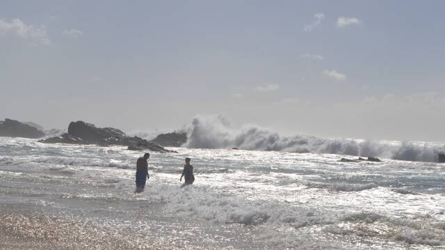 SUNDAY SWELL: German tourists swimming despite massive seas pound Mystery Bay on Sunday morning as the current East Coast Low sulks off Narooma Bermagui. Photo Stan Gorton