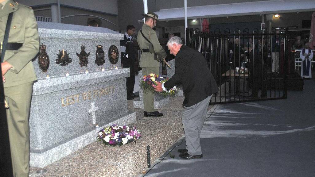 LEST WE FORGET: Club Narooma president Graham Reeve lays a wreath at the Narooma Dawn Anzac Day service.