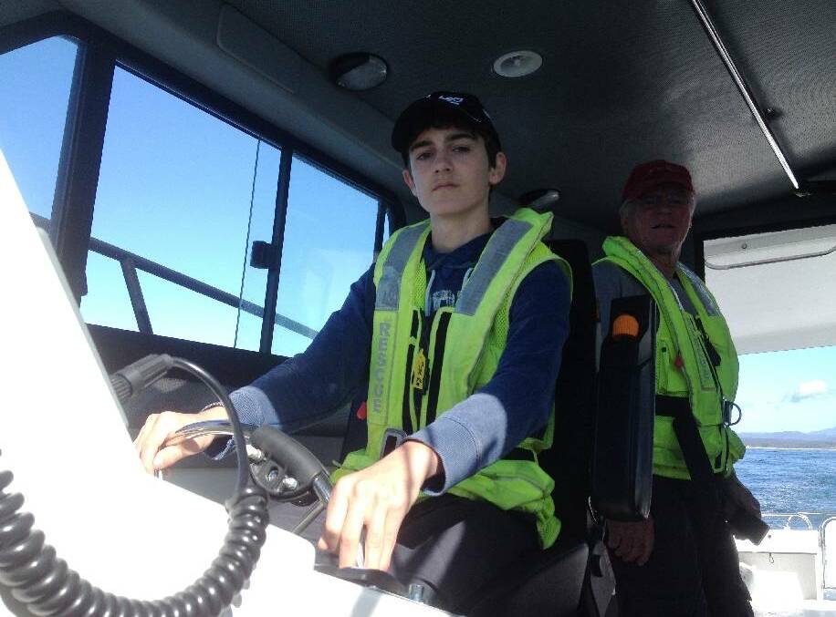 AT THE HELM: German student Phillip Adam at the helm of BG30, the Bermagui Marine Rescue vessel. 
