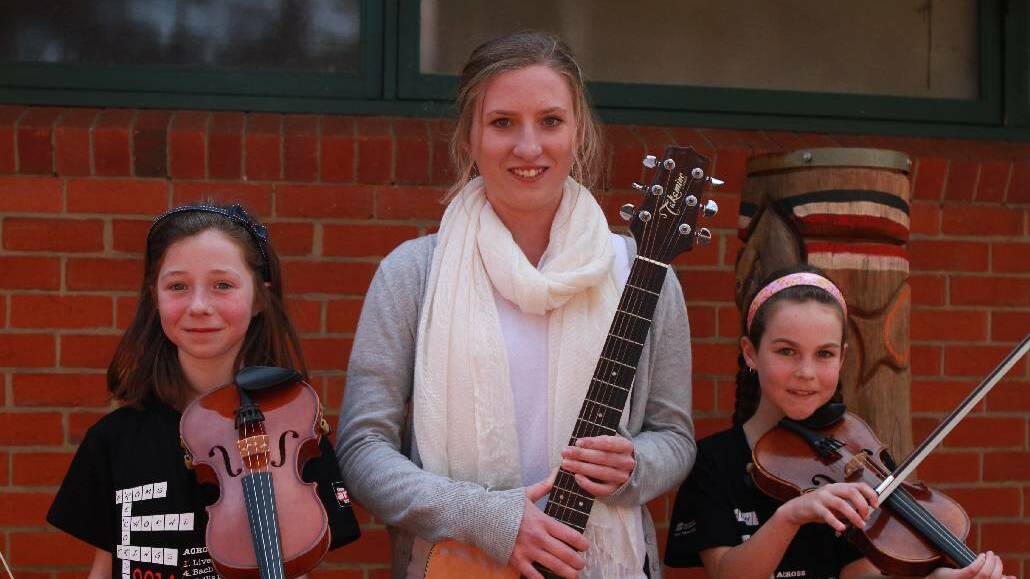 Narooma Public School students Lucy Woolnough, left and Ruby Efraemson, right with Narooma High Year 5 Music student, Sam Sly. The girls are heading to Sydney to perform at the Sydney Opera House in the four part series of the Festival of Instrumental Music. 