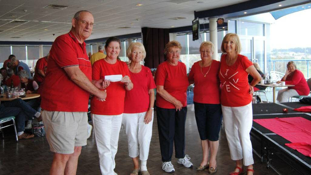 RED INSTEAD: Doug Williams handing over the check to Cathy Milligan, Doreen Monks, Carol Williams, Val Sloane and Sue Fahey.