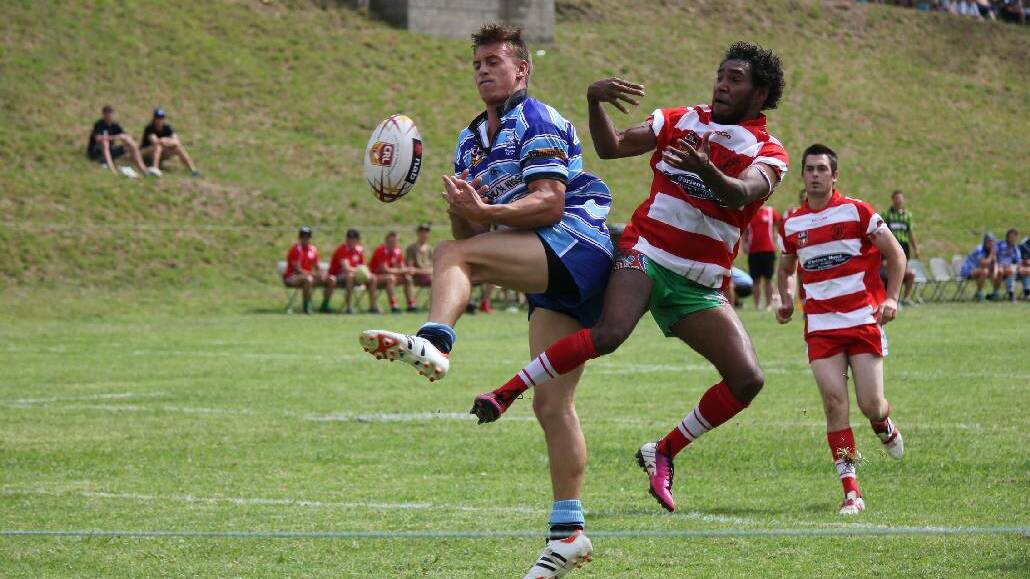 RUGBY NINES: Narooma Devils player Jermaine Ballengarry takes on a Moruya player backed up by Daniel Mayberry during the Bemboka 9’s on Sunday.
