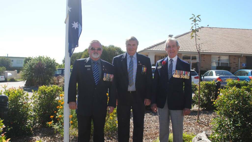 FLAG RAISING: Narooma RSL sub branch members Reg Maxted, Des Burridge and Buzz Bryant prepare to raise the flag at Sir James on Thursday morning.