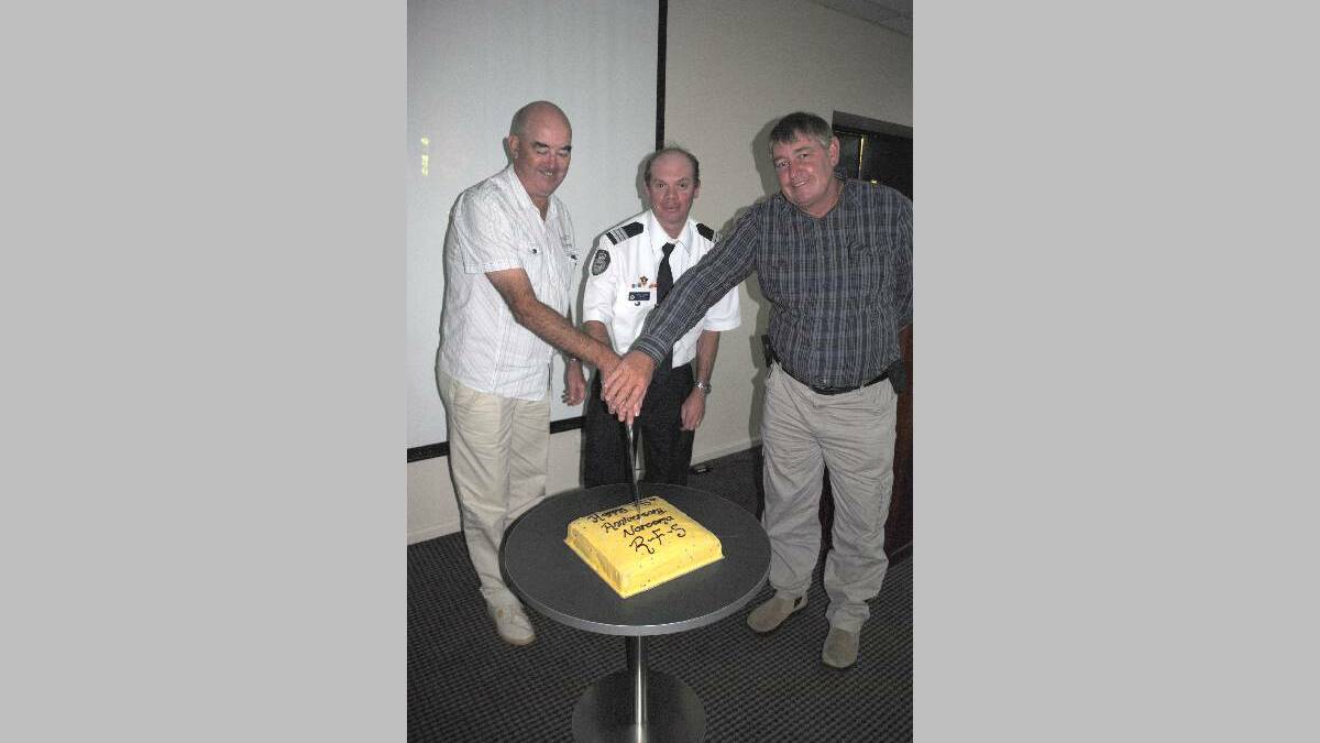 RFS CAKE: Cutting the 75th Anniversary cake for the Narooma Rural Fire Brigade are Euro Group South two Mick Marchini, Narooma captain Adrian Cooper and Tilba captain Bruce Allen.