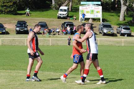 HEARTFELT HANDSHAKES:  Narooma Lions player Wayne Partlett receives a pat on the back and a handshake from an Ansilee player after playing in the practice match in Narooma on Saturday. The winning score can also be seen in the background. 