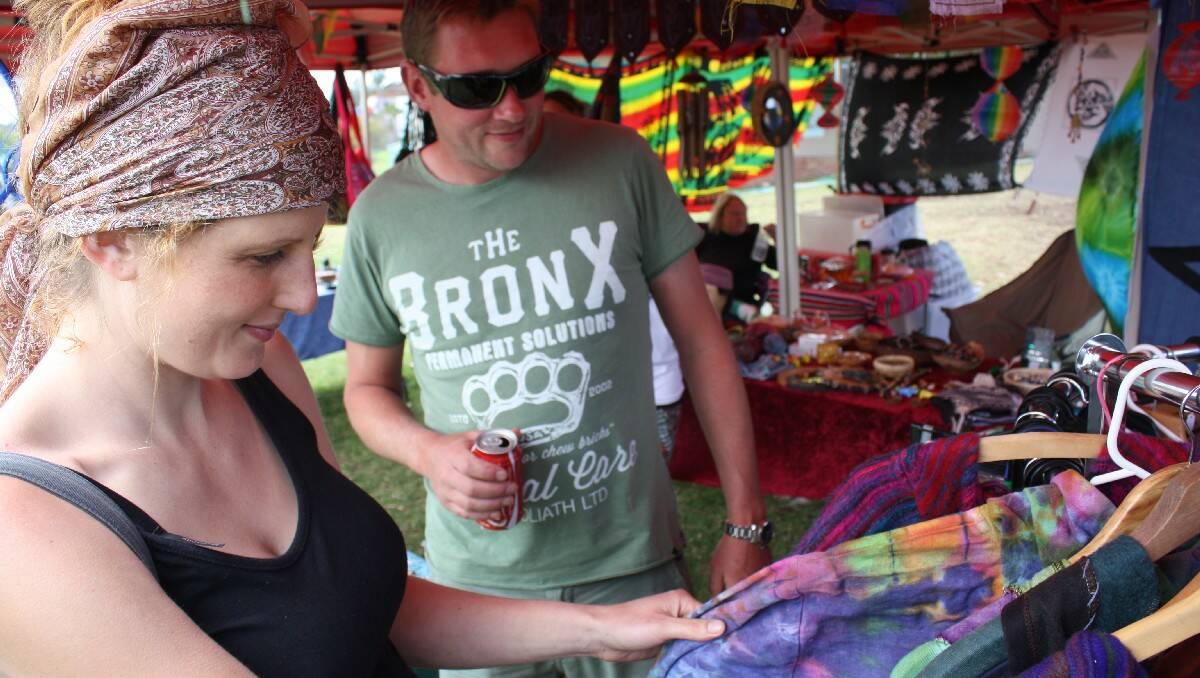 Adrian Preen and Sophia Walsh inspect some of the colourful items on sale at the Tathra election day market.