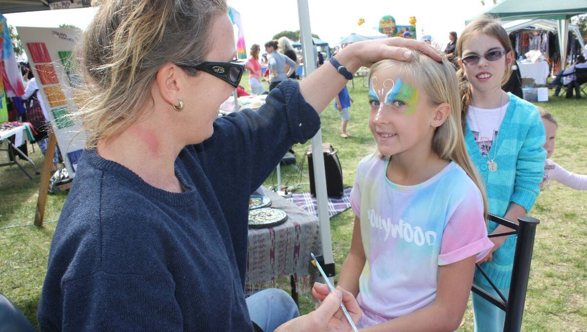 Leiani Otton has her face painted by Lise Hetzel at Tathra.